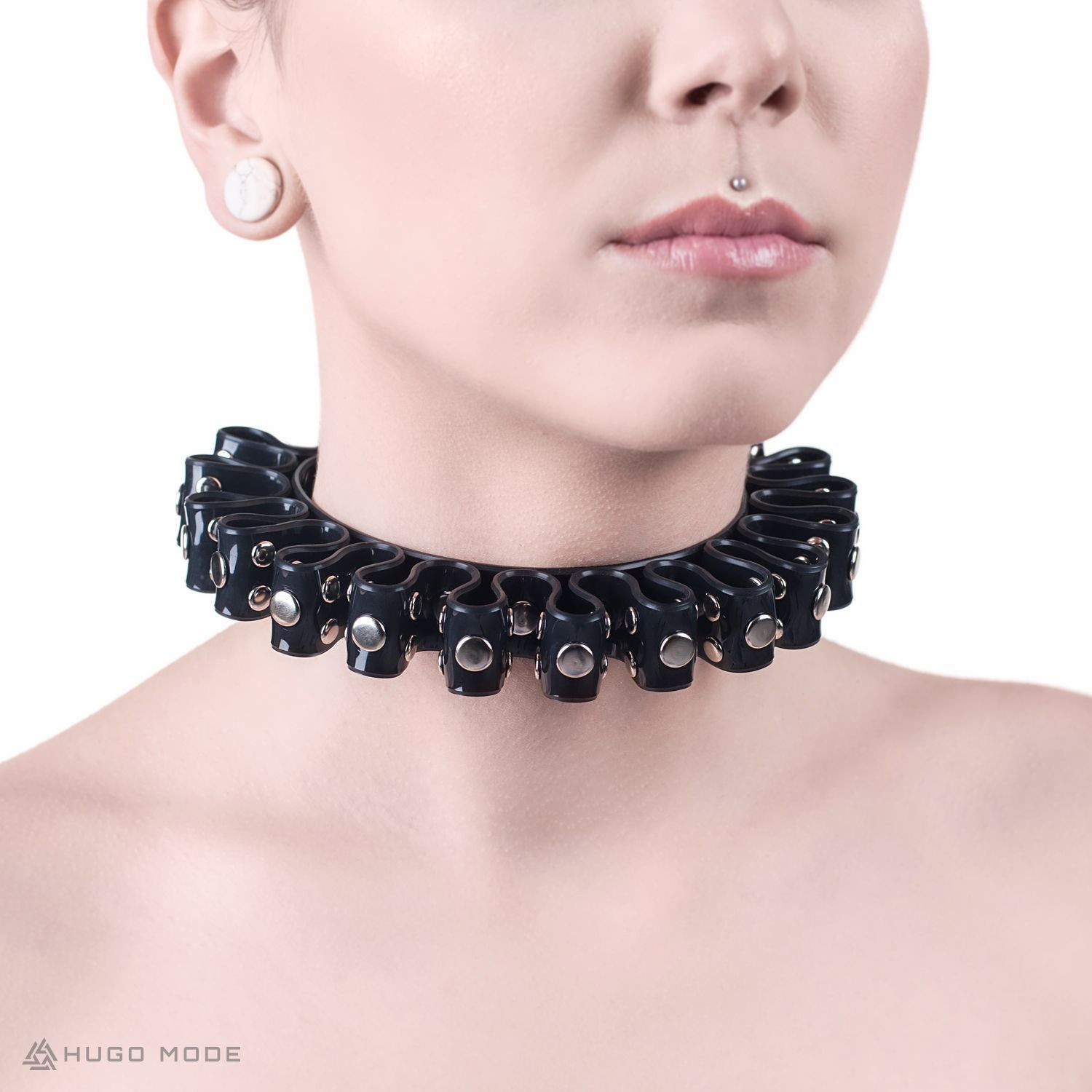 Ein Choker Halsband mit ausgeprägten Falten um den ganzen Umfang, verziert mit Nieten.
