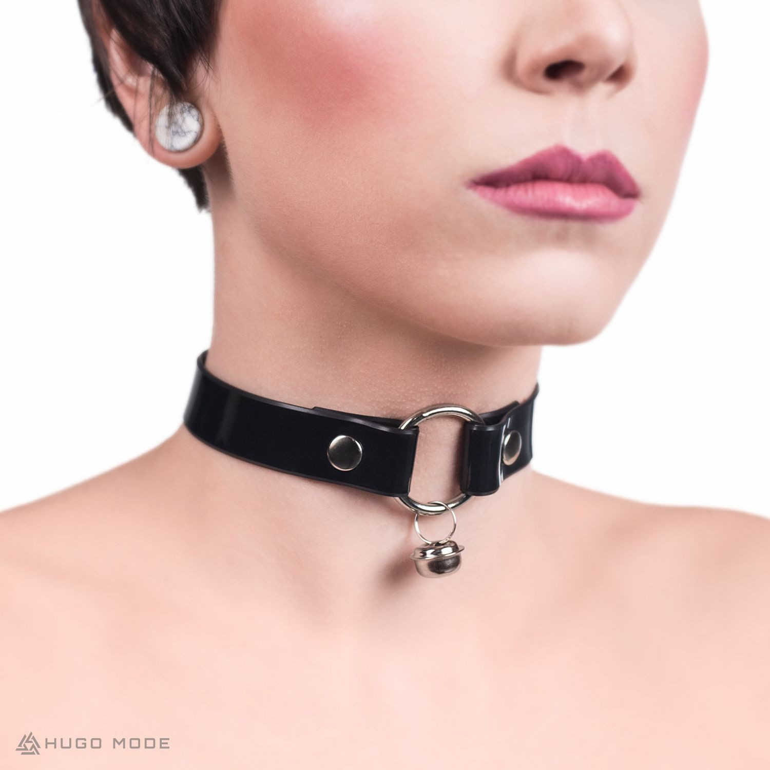 A neck choker connected with a ring with a jingle bell.