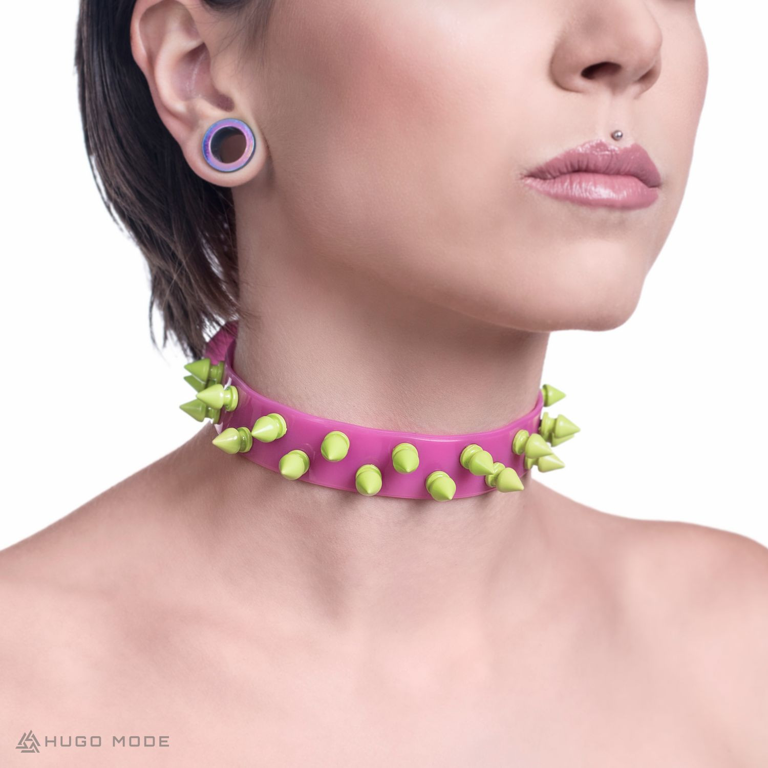 A pink choker necklace with green spikes.